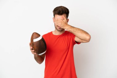 Beyaz arka planda ragbi oynayan beyaz tenli genç bir adam elleriyle gözlerini kapatıyor. Bir şey görmek istemiyorum.