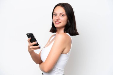 Young caucasian woman isolated on white background holding a mobile phone and with arms crossed