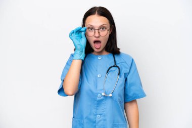 Young nurse caucasian woman isolated on white background with glasses and surprised