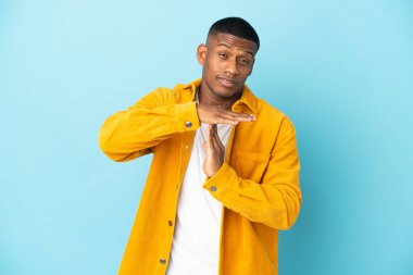 Genç latin adam mavi arka planda izole edilmiş.