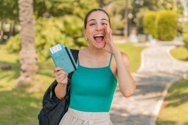 Dışarıda pasaportu olan genç ve güzel bir kadın ağzı açık bağırıyor.