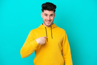 Mavi arka planda yalıtılmış beyaz bir adam. Şaşırtıcı bir yüz ifadesi var.