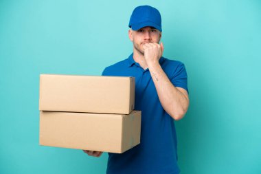Teslimat yapan beyaz adam mavi arka planda izole edilmiş. Şüpheleri var.