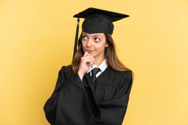 Genç üniversite mezunu. Sarı arka planda izole edilmiş.