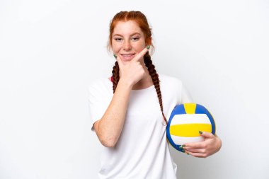 Beyaz arka planda izole edilmiş, mutlu ve gülümseyen, voleybol oynayan beyaz tenli genç bir kadın.