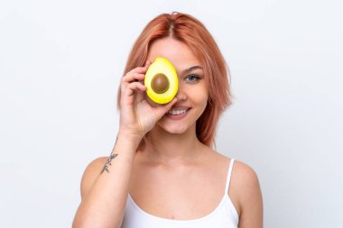 Beyaz arka planda izole edilmiş genç bir Rus kızı elinde bir avokado tutarken gülümsüyor. Portreyi kapat