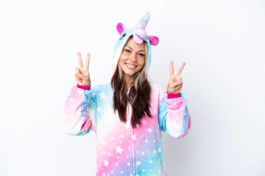 Beyaz arka planda izole edilmiş tek boynuzlu at pijaması giyen genç Rus kadın iki eliyle zafer işareti gösteriyor.