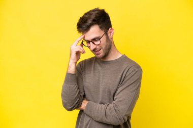 Sarı arka planda izole edilmiş genç beyaz adam gülüyor.