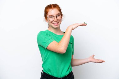 Beyaz arka planda izole edilmiş genç, kırmızımsı bir kadın ilan vermek için kopyalama alanı tutuyor