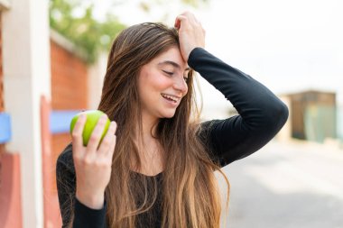 Açık havada elmalı genç beyaz bir kadın bir şeyin farkına vardı ve çözümü arıyor.
