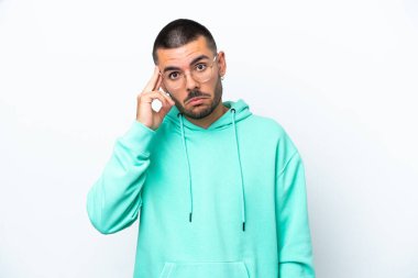 Beyaz arka planda izole edilmiş genç beyaz bir adam bir fikir düşünüyor.