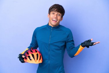 Genç beyaz adam, mor arka planda izole edilmiş, şok olmuş yüz ifadesi var.