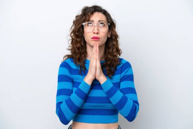 Beyaz arka planda izole edilmiş genç beyaz kadın avuç içlerini bir arada tutuyor. İnsan bir şey ister.