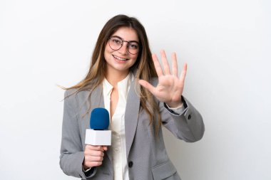 Beyaz arka planda izole edilmiş beyaz televizyon sunucusu genç beyaz kadın parmaklarıyla beşi sayıyor.