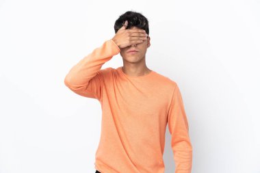 İzole edilmiş beyaz arka planı olan genç bir adam gözlerini elleriyle kapatıyor. Bir şey görmek istemiyorum.