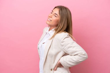 Pembe fırında izole edilmiş beyaz bir kadın gayret gösterdiği için sırt ağrısı çekiyor.