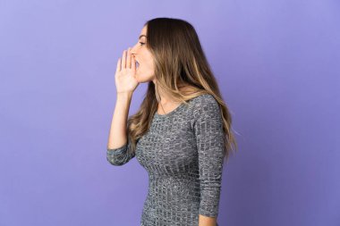 Mor arka planda izole edilmiş genç Romen kadın ağzı sonuna kadar açık bağırıyor