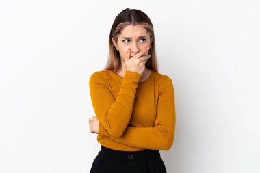 Beyaz arka planda izole edilmiş genç beyaz bir kadın. Şüpheleri var ve kafası karışmış bir yüz ifadesi var.