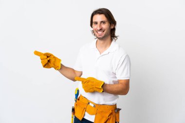 İzole edilmiş arka planda genç elektrikçi parmağı yana gösteriyor.