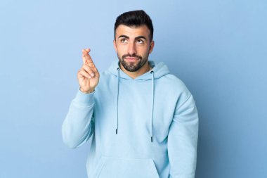 İzole edilmiş mavi arka planı olan beyaz bir adam, şans diliyor ve en iyisini diliyor.