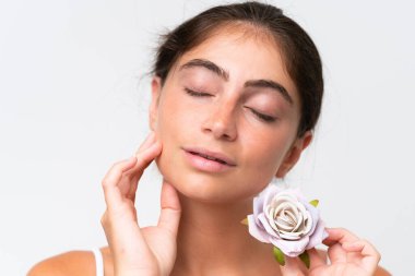 Young Pretty caucasian woman isolated on white background holding flowers. Close up portrait