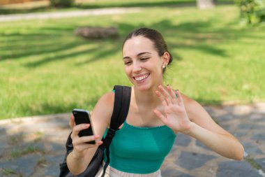 Dışarıda cep telefonu kullanan genç ve güzel bir kadın.