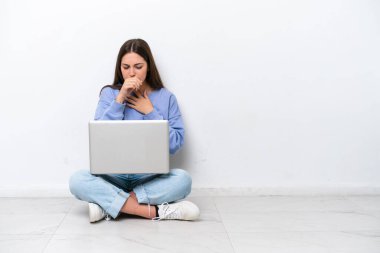 Diz üstü bilgisayarı olan, beyaz arka planda izole edilmiş beyaz bir kadın öksürükten muzdarip ve kötü hissediyor.