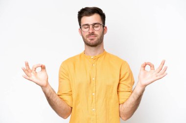 Beyaz arka planda Zen pozisyonunda beyaz tenli genç bir adam
