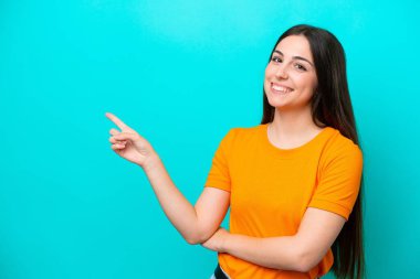 Mavi arka planda izole edilmiş genç, beyaz bir kadın var.