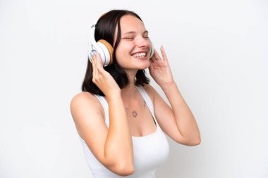 Beyaz arka planda izole edilmiş beyaz bir kadın müzik dinliyor ve şarkı söylüyor.