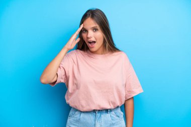 Mavi arka planda izole genç beyaz kadın bir şey fark etti ve çözüme niyetlendi.