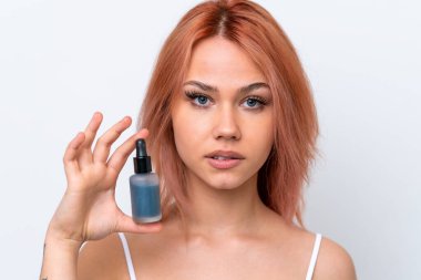 Beyaz arka planda izole edilmiş genç bir Rus kız elinde bir serum tutuyor. Portreyi kapat