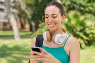 Dışarıda cep telefonu kullanan genç ve güzel bir kadın.