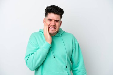 Beyaz arka planda diş ağrısı çeken beyaz tenli genç bir adam.