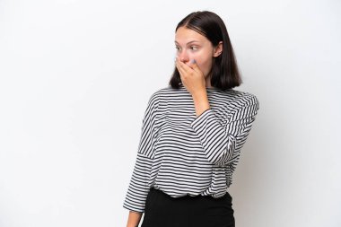 Beyaz arka planda izole edilmiş genç beyaz kadın yan tarafa bakarken sürpriz jest yapıyor.