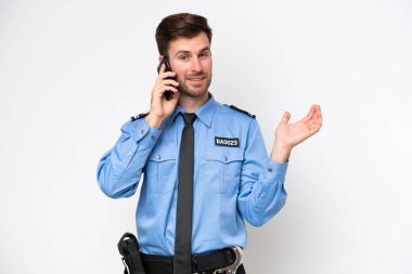 Beyaz arka planda izole edilmiş genç bir beyaz adam cep telefonuyla sohbet ediyor.