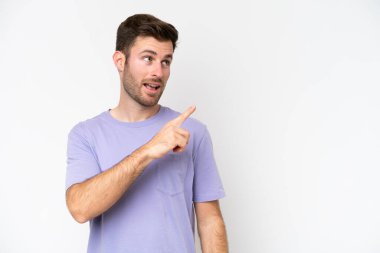 Beyaz arka planda izole edilmiş genç beyaz bir adam çözümü bulmak için parmağını kaldırıyor.