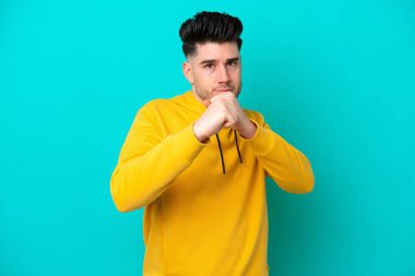 Kafkasyalı genç adam mavi arka planda izole edildi.
