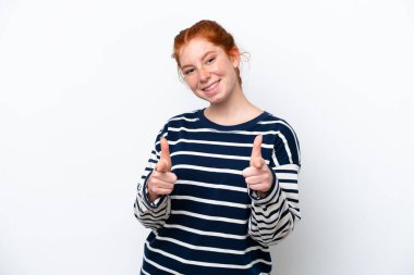 Beyaz arka planda izole edilmiş genç, kırmızı bir kadın ön tarafı işaret ediyor ve gülümsüyor.