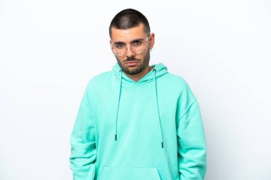 Beyaz arka planda hüzünlü bir ifadeyle izole edilmiş genç beyaz bir adam.