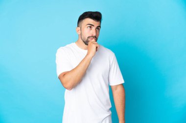 İzole edilmiş mavi arka planda beyaz bir adam var.