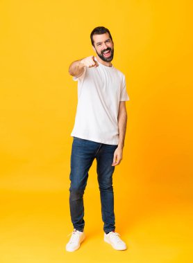 Sarı arka planda sakallı bir adamın uzun pozu kendine güvenen bir ifadeyle seni işaret ediyor.