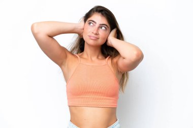 Beyaz arka planda izole edilmiş genç beyaz kadın hayal kırıklığına uğramış ve kulaklarını kapatmış.