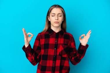 Zen pozunda mavi arka planda izole edilmiş beyaz bir kadın.