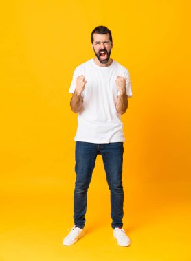 Sakallı bir adamın, izole edilmiş sarı arka planda kötü bir durumdan dolayı hayal kırıklığına uğramış bir fotoğrafı.