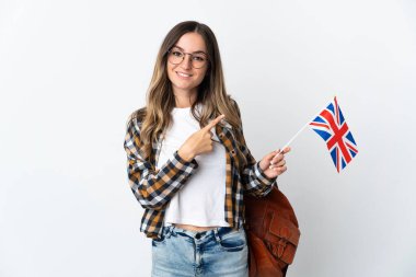 Beyaz arka planda izole edilmiş bir Birleşik Krallık bayrağı taşıyan genç Romen kadın, bir ürün sunmak için kenarı işaret ediyor