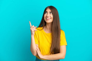 Mavi arka planda izole edilmiş beyaz bir kadın harika bir fikre işaret ediyor.