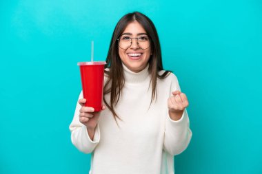 Mavi arka planda gazoz içen beyaz bir kadın zaferi kutluyor.