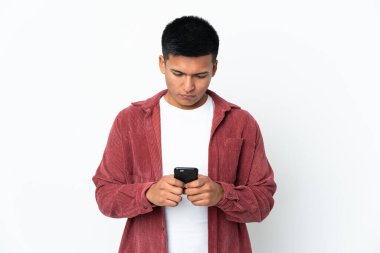 Genç Ekvadorlu adam beyaz arka planda cep telefonu kullanarak izole edilmiş.