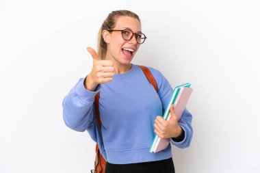 Beyaz arka planda beyaz tenli genç bir kadın var. Başparmakları havada. Çünkü iyi bir şey oldu.